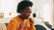 © peopleimages.com - Coughing, sick and black woman in home with flu, cold or allergies with viral infection. Illness, recovery and African female person with respiratory issue, tuberculosis or asthma in living room.