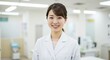 © AnilaStudio - Smiling Asian doctor wearing white coat in hospital
