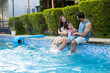 © GAJENDRRA BHATI  - Young indian family enjoy at swimming pool in summer holiday, India parents with child daughter having fun relaxing together at hotel resort vacation. Bonding and togetherness