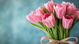 A rustic wooden surface serves as the backdrop for a charming arrangement of pink tulips.