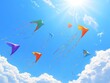 © Liu - Colorful kites flying in a clear blue sky with the sun shining brightly