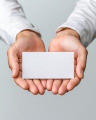 Aufkleber - Two hands gently hold a blank white rectangular card perfect for your message or design presentation against a neutral background.