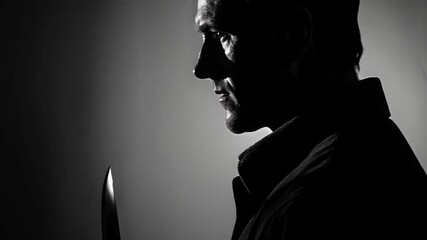 Wall Mural - a dark figure with a knife in his hand, illuminated by a gloomy light. perfect for thrillers, horror