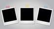 © Candra - ai image displays three empty instant photo frames, secured with colorful tape pieces against a clean, plain grey background wall.