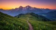 © Katsyarina - Winding hiking path on mountaintop meadow at sunset. Serene scenic alpine panorama for travel, trekking, peaceful retreat, breathtaking nature and outdoor adventure