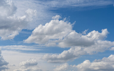 Wall Mural - blue sky with fluffy white close up clouds.
