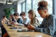 © Bhain - Focused schoolchildren using cellphones while sitting at desks in school classroom interior during break, copy space