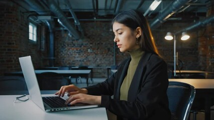 Poster - a woman sits at a table with her laptop, focused on her work.