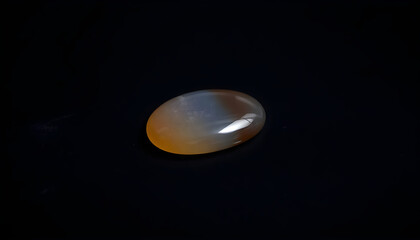 Wall Mural - white and yellow oval shaped object on a black surface