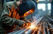 © miss irine - Welder at work, wearing protective mask. Sparks and smoke when welding metal. Focus on craftsmanship. Man making seams on metal surface in industrial workshop.
