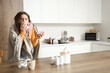 © Pixel-Shot - Ill young woman with thermometer and tissue sneezing in kitchen
