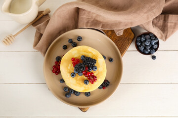 Wall Mural - plate of sweet pancakes with different fresh berries on white wooden background