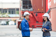 © DG PhotoStock - Businesswoman and logistic or shipyard engineer have a discussion or business due at container yard.