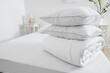© Pixel-Shot - Folded blanket with pillows on bed in light room