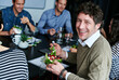 © peopleimages.com - Meeting, eating and portrait of businessman with salad in office for team building lunch for collaboration. Discussion, smile and male designer with colleagues enjoying healthy meal in workplace.