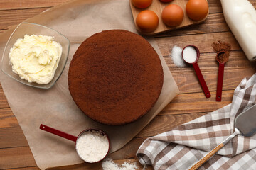 Wall Mural - delicious chocolate sponge cake with ingredients on wooden background