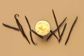 Wall Mural - bowl of tasty pudding with flower and vanilla sticks on color background