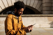 © Jorge Elizaquibel - Young man browsing on smartphone in urban setting