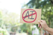 © Sanhanat - Close up hand holds paper card with No AI,  prohibition sign, outdoor nature background. Concept, disagree, anti or don't support to use AI or Artificial Intelligence in daily life.