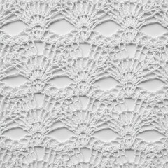 Delicate crochet pattern close up on white background