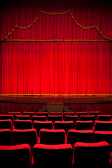 Empty Theater Seats Facing Red Velvet Stage Curtain