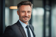 © ROni051 - Confident Professional Man in Suit Smiling in Modern Office with Warm Lighting – 50mm Portrait.