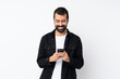 © luismolinero - Young man with beard over isolated white background sending a message with the mobile