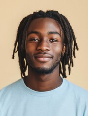 Poster - Portrait of a Cheerful Young Man with Dreadlocks Smiling Confidently in Front of a Neutral Background