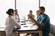 © fizkes - Doctor offer solution. Confident millennial man surgeon speak to multicultural colleagues sitting at table on team briefing explain creative idea propose innovative changes for patient healthcare plan