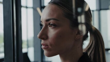 Aufkleber - Pensive businesswoman stands near window in modern office, contemplating business strategies, observing colleagues in background, reflecting on challenges and opportunities
