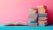 © NCSF - Vintage Books on Blue Table with Open Book, A collection of vintage books stacked on a blue wooden table against a pink background