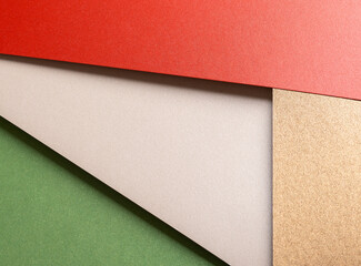 Aufkleber - Paper background with matte texture. Layered diagonal sheets in bright red, pastel green, champagne, soft beige, and metallic brown tones, elegant festive composition, vivid warm color contrast..