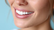 © Ali Hamza Tullah - Healthy White Teeth and Soft Smile on Woman’s Face, Cropped Close-Up with Blue Studio Backdrop, woman smile, white teeth, healthy teeth, close-up mouth, gentle smile, blue background, dental care,