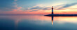 © john - A Lighthouse Stands Alone in a Calm Sea at Sunset