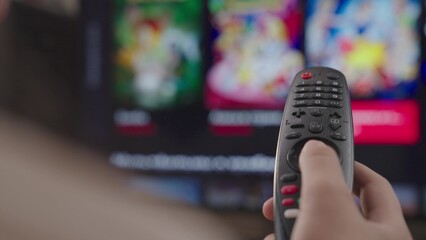 girl controls the tv remote control in room at home, rest on weekend, remote control of a modern sma