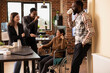 © DC Studio - Colleagues enjoying casual office chatter, bonding over shared experiences in modern startup environment. Laughter fills the modern workspace as multiethnic employees take a break at the office desk.