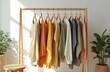 © Maryna - Collection of colorful female clothes hanging on wooden rack. Variety of apparel shades arranged in a row. Fashion store display with casual attire, shopping, textile concept, closet business.