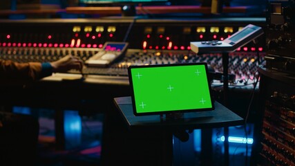 Leinwandbilder - African american tracking engineer works with greenscreen, operates audio console with moving faders and colored meters. Specialist pressing buttons and faders to edit audio recordings. Camera A.