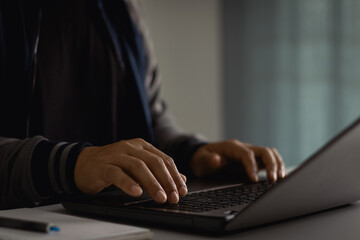 close up of a freelance developer's hands typing program code on laptop keyboard in coworking. busin