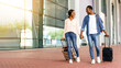 © Prostock-studio - Ready for travel. Happy black couple walking with luggage near airport building, excited about future trip, free space