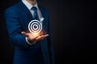 © MuhammadFarooq - Business achievement objective target concept, strategic planning for business growth and target customer group. Businessman holding target icon for business objective. Business professional, holograp