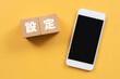 © ELUTAS - 設定と書かれたブロックとスマホ
