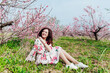 © dmitriisimakov - woman smiling in flower dress in spring blooming garden