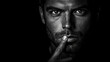© Inna - Black and white photo of a man with a finger on his lips, symbolizing silence or secrecy, against a black background. His gaze reflects mystery and confidence.