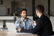 © fizkes - Two diverse businesspeople lead collaborative discussion in corporate boardroom. Busy handsome CEO executive Indian manager speaks, consulting, sharing expertise and insights with colleague or client