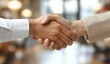 © imagemir - A close-up of a firm handshake between a male and female business partner, symbolizing trust and collaboration.