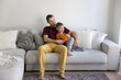 © fizkes - Emotional connection and dreamy moments. Happy caring single dad relax on sofa at living room hug smiling little school age child son talk dream together with kid create plans for future. Copy space
