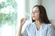 © PheelingsMedia - Woman at home vaping and blowing smoke