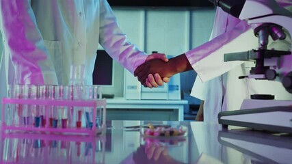 Wall Mural - professional scientists wearing lab coats shaking hands, confirming successful collaboration in cutt