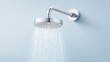 © kiimoshi - A modern shower head dispensing a refreshing cascade of water against a soft blue background, symbolizing relaxation and well-being in a contemporary bathroom setting.